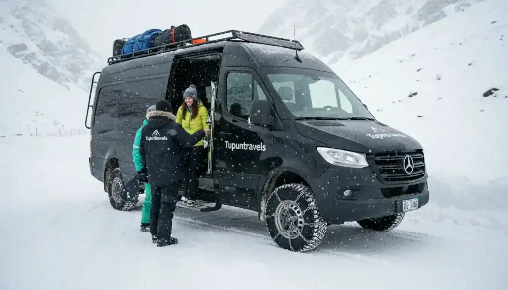 Un vehículo 4x4 de Tupuntravels con cadenas en las ruedas transportando esquiadores en una ruta de alta montaña con mucha nieve.